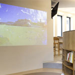 1階キッズルームの壁に投影された画面に、子供たちが描いたキャラクターが登場します。